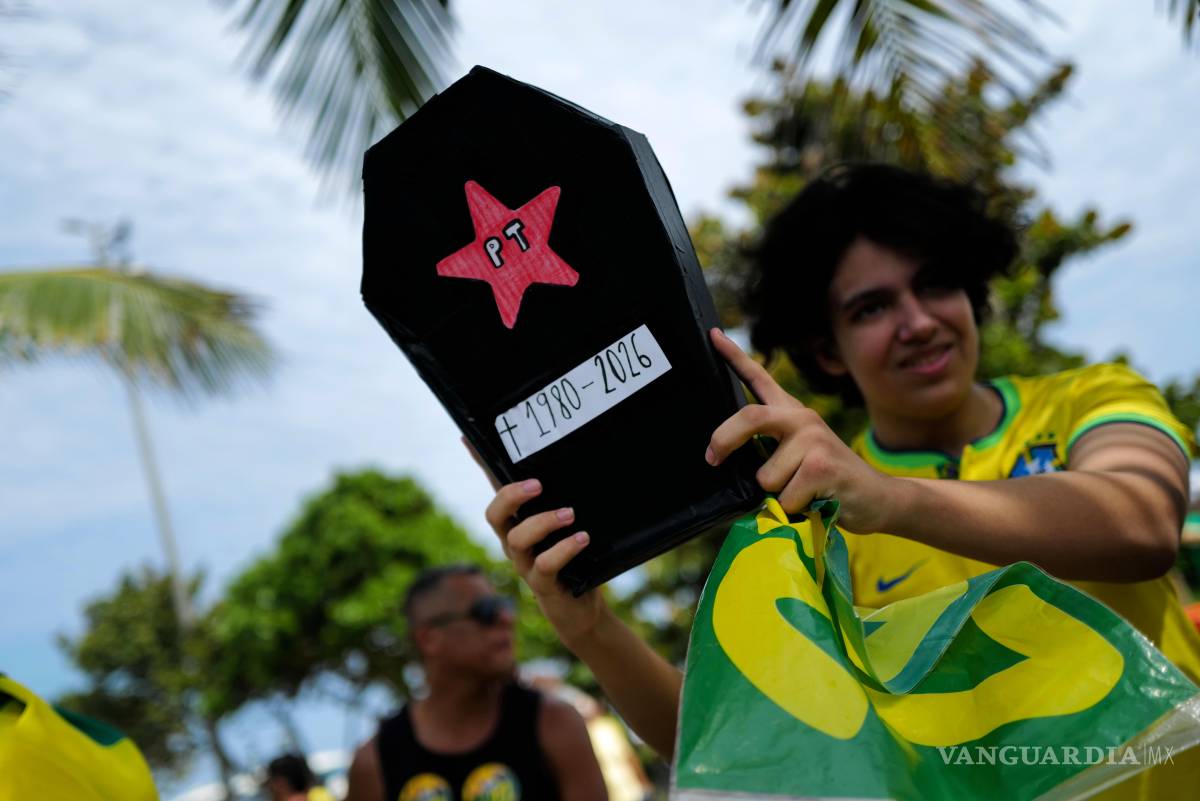 $!Un partidario del candidato presidencial Flavio Bolsonaro, con un ataúd que lleva el símbolo del Partido de los Trabajadores, un día antes de la segunda vuelta en Río de Janeiro, Brasil.