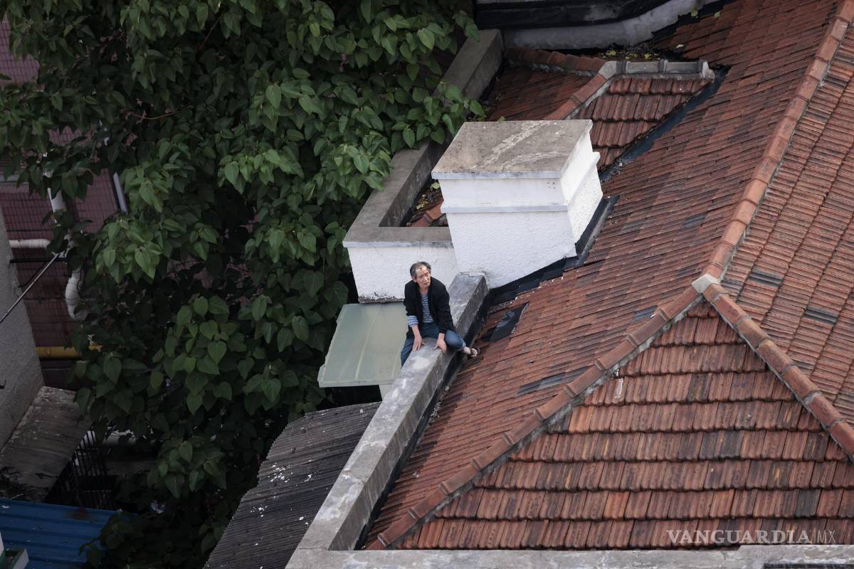 $!Un hombre se sienta en el techo de su casa en un complejo residencial en Shanghái, China.