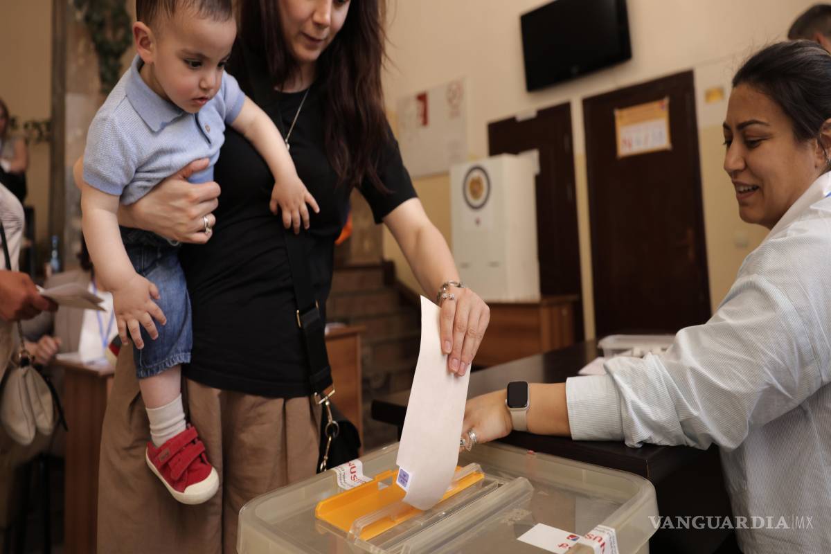 $!Una mujer con un niño en brazos emite su voto en un colegio electoral durante las elecciones parlamentarias en Ereván, Armenia.