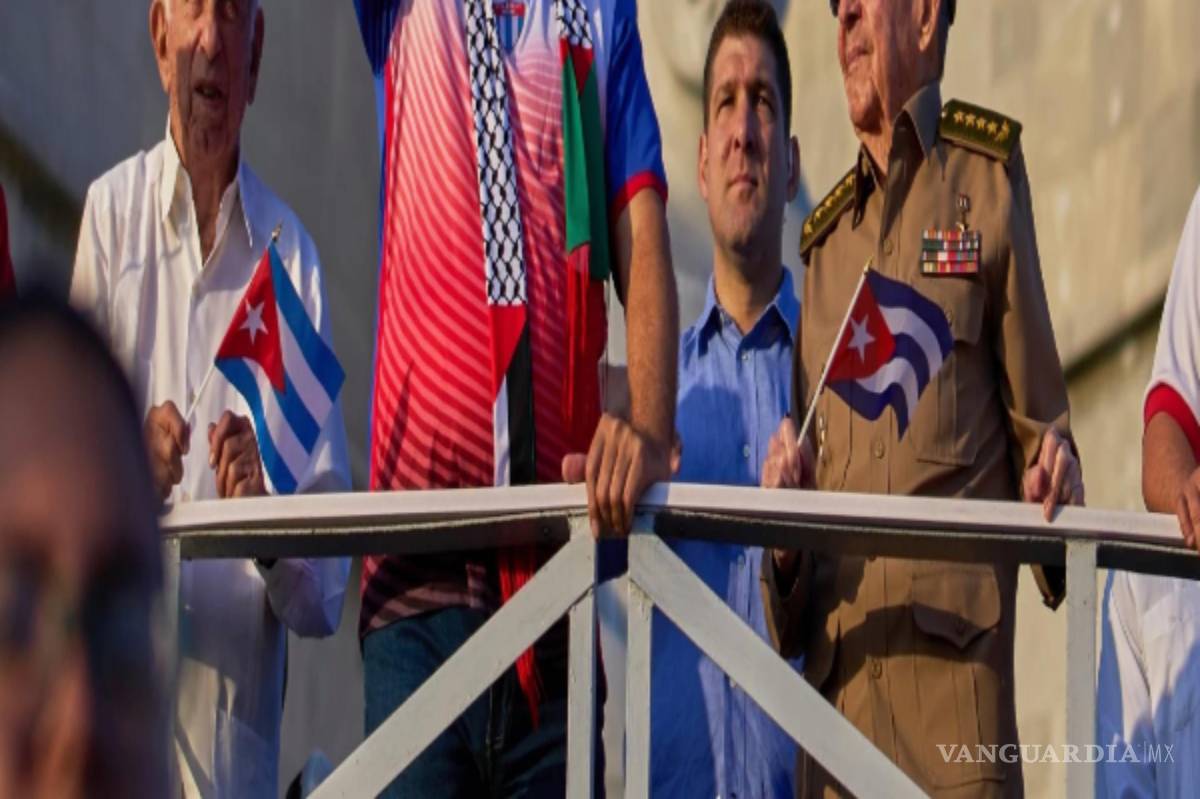 $!El presidente de Cuba, Miguel Díaz-Canel, levanta una bandera cubana Een el desfile del Primero de Mayo junto a Raúl Castro, el 1 de mayo de 2025.