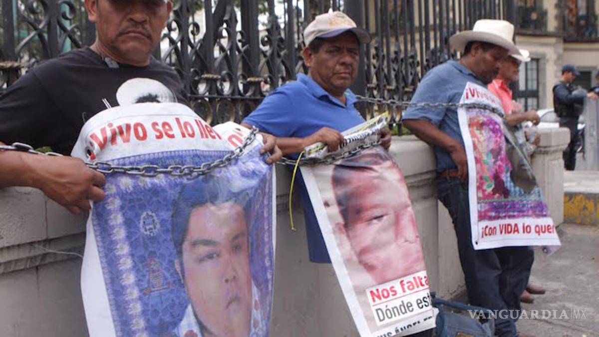 Padres de los 43 se encadenan en rejas de la Segob
