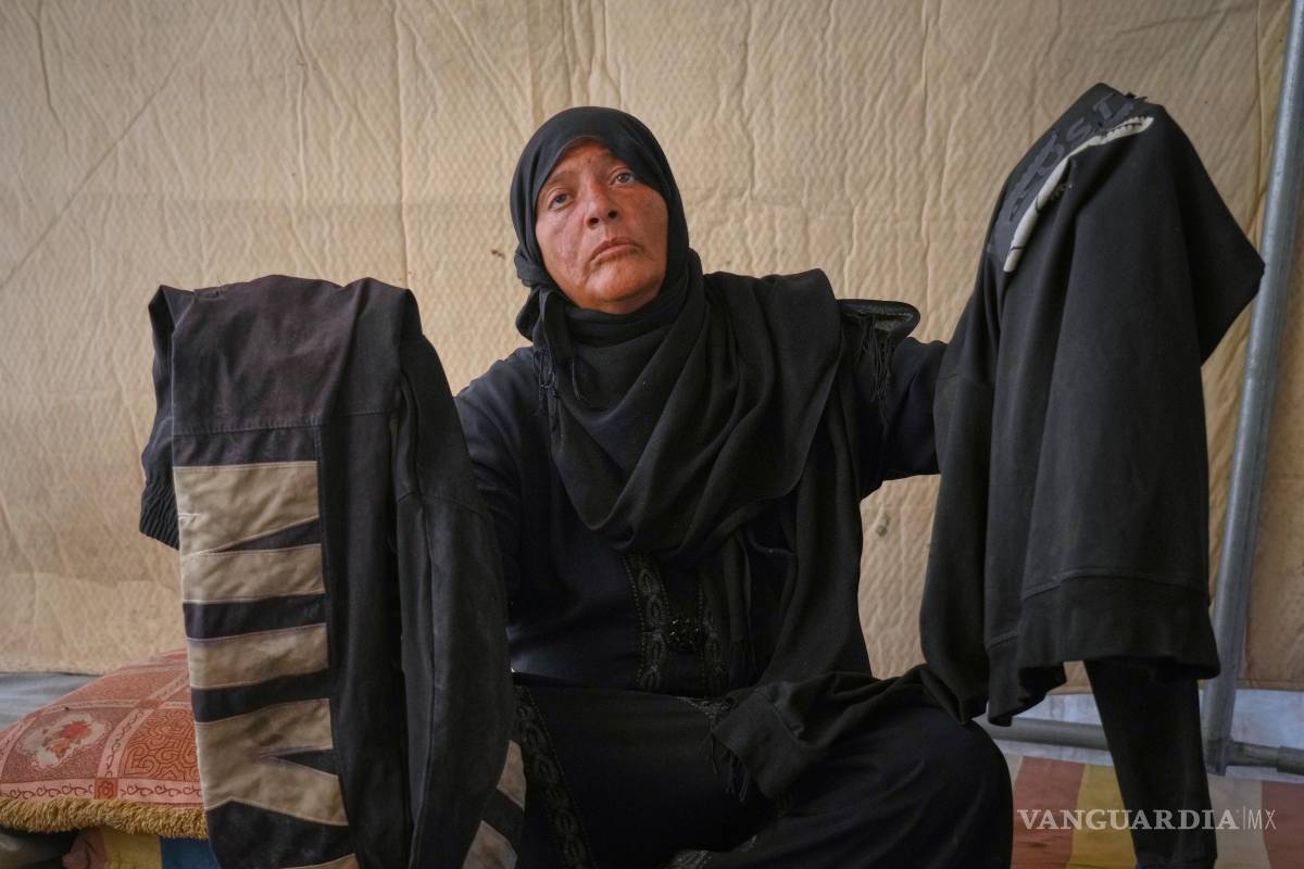 $!Fadwa al-Ghalban sostiene ropa de su hijo Mosaab, en su tienda en Muwasi, Gaza. Fadwa no ha tenido noticias de Mosaab desde julio.