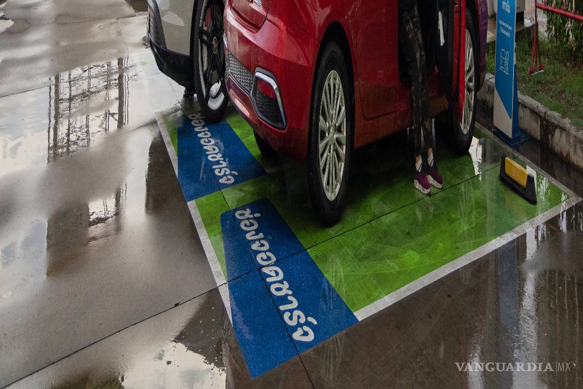 $!Chanakan Sa-Nguanslip espera a que se cargue su vehículo eléctrico de fabricación china en una gasolinera de Kanchanaburi, Tailandia.