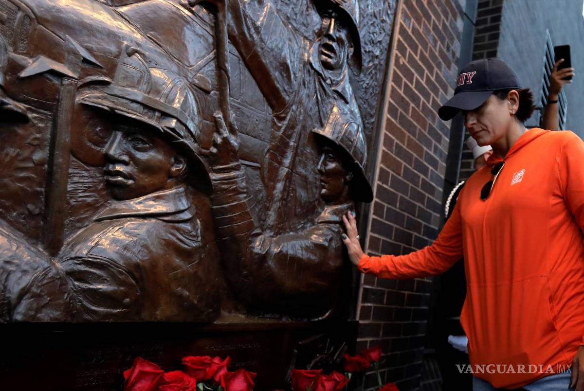 $!Una mujer toca el socorro del bombero en la ceremonia Tunnel to Towers para conmemorar a todos los que murieron en los ataques terroristas del 11 de septiembre de 2001 en la estación de bomberos Ladder 10 en el bajo Manhattan, en Nueva York, Nueva York. EFE/EPA/Peter Foley