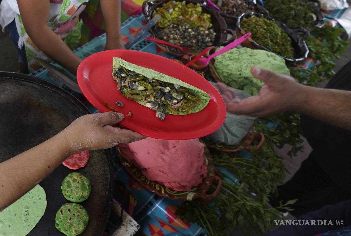 $!Un vendedor sirve nopales y huitlacoche en una tortilla de color verde en la Feria de Comida Prehispánica en la alcaldía Iztapalapa de la Ciudad de México.
