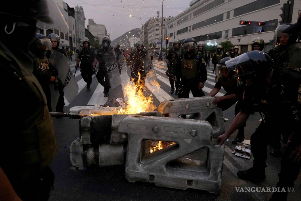 $!La policía desmantela una barricada en llamas levantada por partidarios del derrocado presidente Pedro Castillo durante enfrentamientos con la policía.