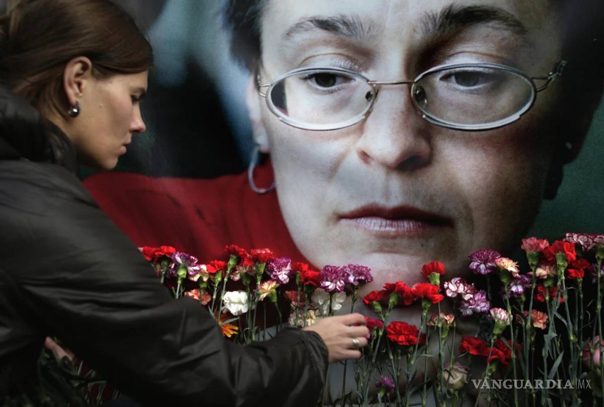 $!Fotografía del 7 de octubre de 2009. Una mujer deposita flores ante un retrato de la asesinada periodista rusa Anna Politkóvskaya, en Moscú, Rusia.