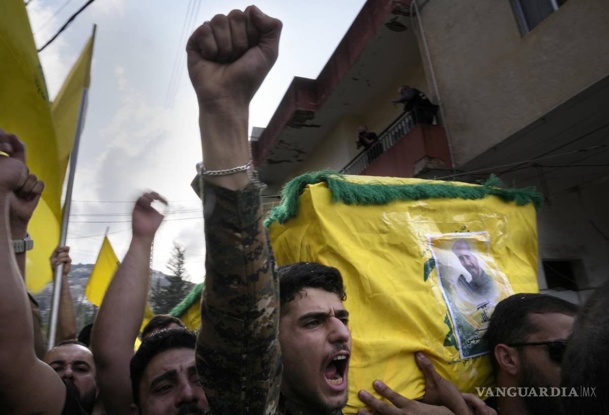 $!Un combatiente de Hezbollah carga el ataúd de uno de sus compañeros que murió por artillería israelí, mientras grita consignas durante una procesión fúnebre, el martes 10 de octubre de 2023, en el poblado de Khirbet Selm, en el sur de Líbano. El grupo respaldado por Irán anunció el lunes por la noche que tres de sus elementos murieron luego de un intenso bombardeo israelí contra distintos poblados en el sur de Líbano. (AP Foto/Hussein Malla)