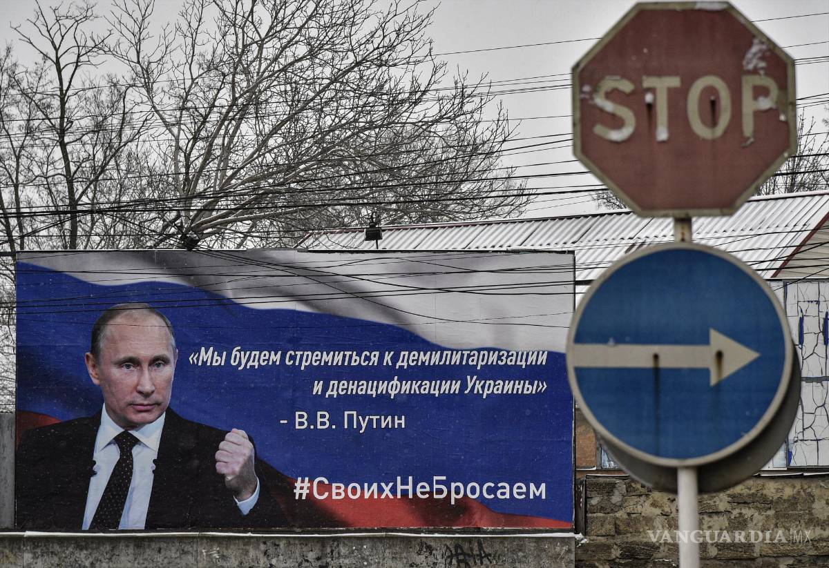 $!Un cartel con la imagen de Vladimir Putin que dice “Nos esforzaremos por la desmilitarización y desnazificación de Ucrania” en Crimea.EFE/EPA/STRINGER