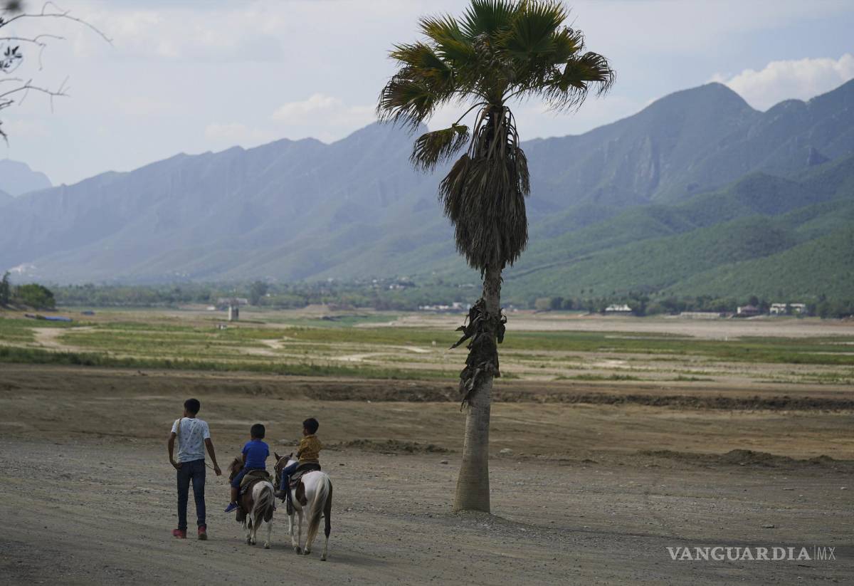 $!Niños montan a caballo frente a la playa en la represa La Boca que abastece de agua a la ciudad norteña de Monterrey en Santiago, Nuevo León.