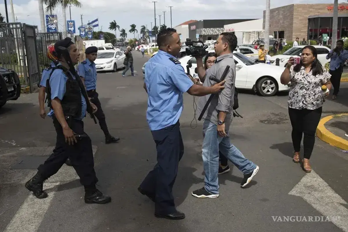 $!Un agente de la Policía Nacional obstruye el paso a un camarógrafo en una protesta en Managua para exigir la liberación de presos políticos.