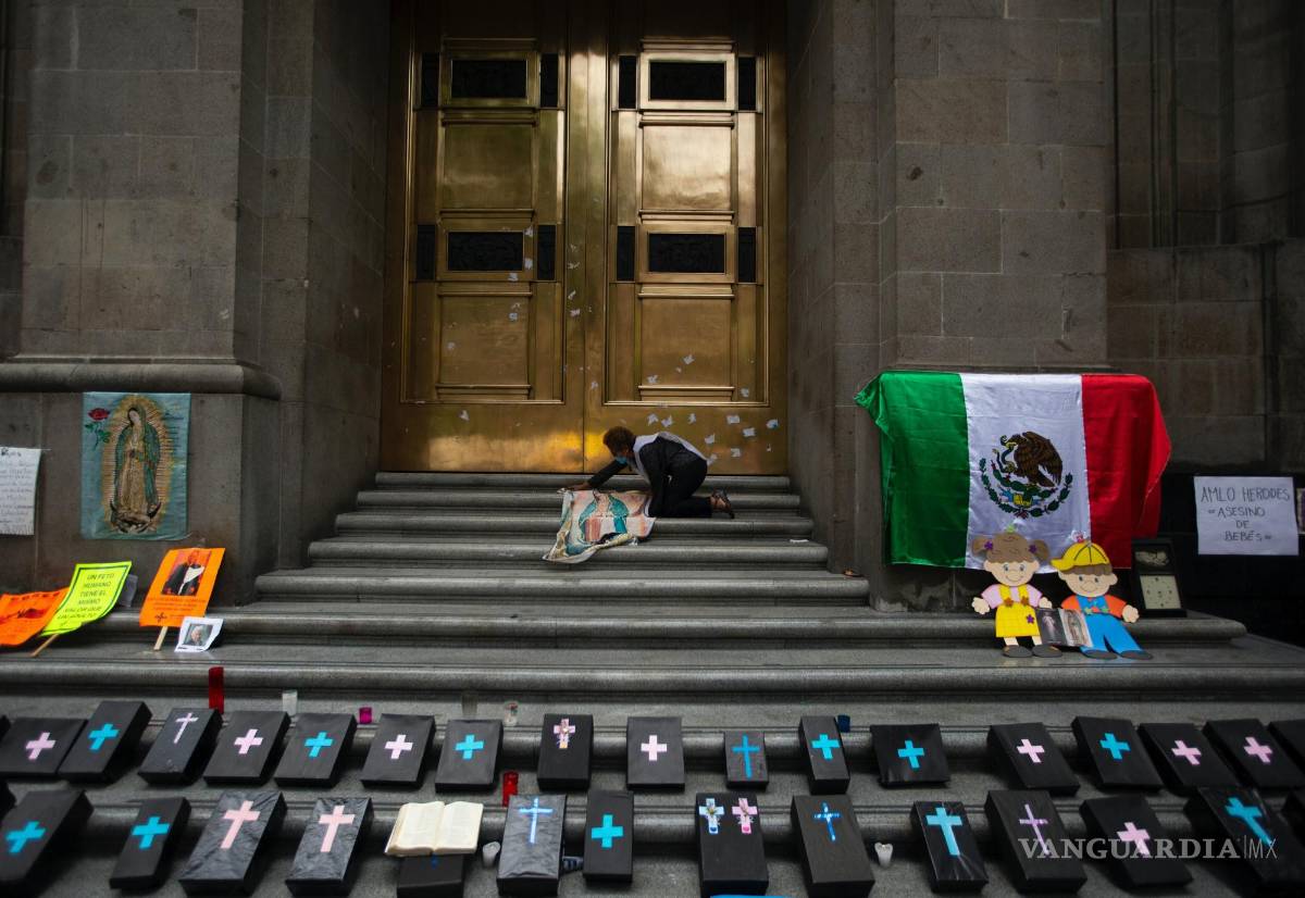 $!Activista contra el aborto coloca un panel de tela de Nuestra Señora de Guadalupe junto a pequeños ataúdes simulados en la entrada de la Corte Suprema.
