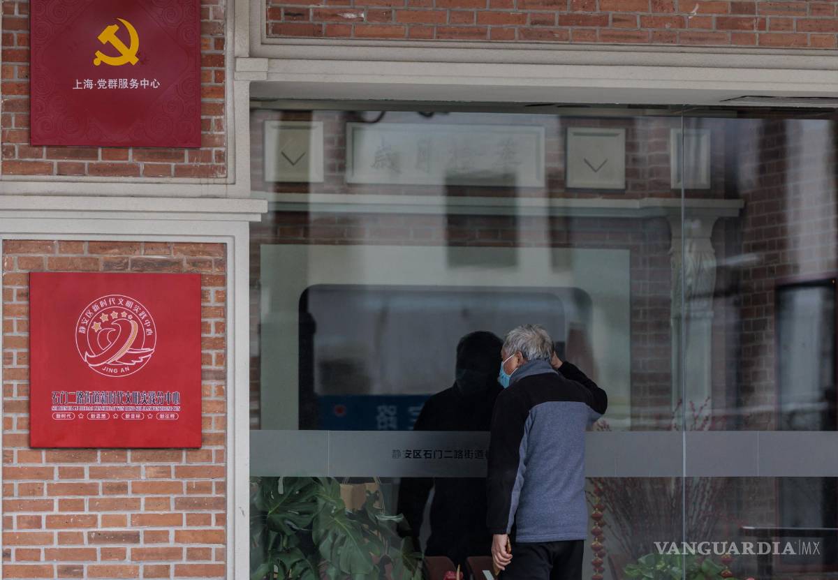 $!Un hombre mira a través de la ventana de la sede local cerrada del Partido Comunista en medio del cierre, en el lado Puxi de la ciudad, en Shanghai, China.