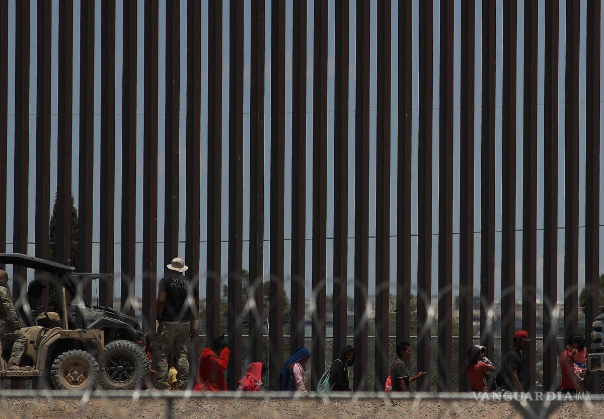 $!Policías de la Guardia Nacional de Texas dialogan por medio de altavoces con migrantes en el muro que divide a México con Estados Unidos, en Ciudad Juárez.