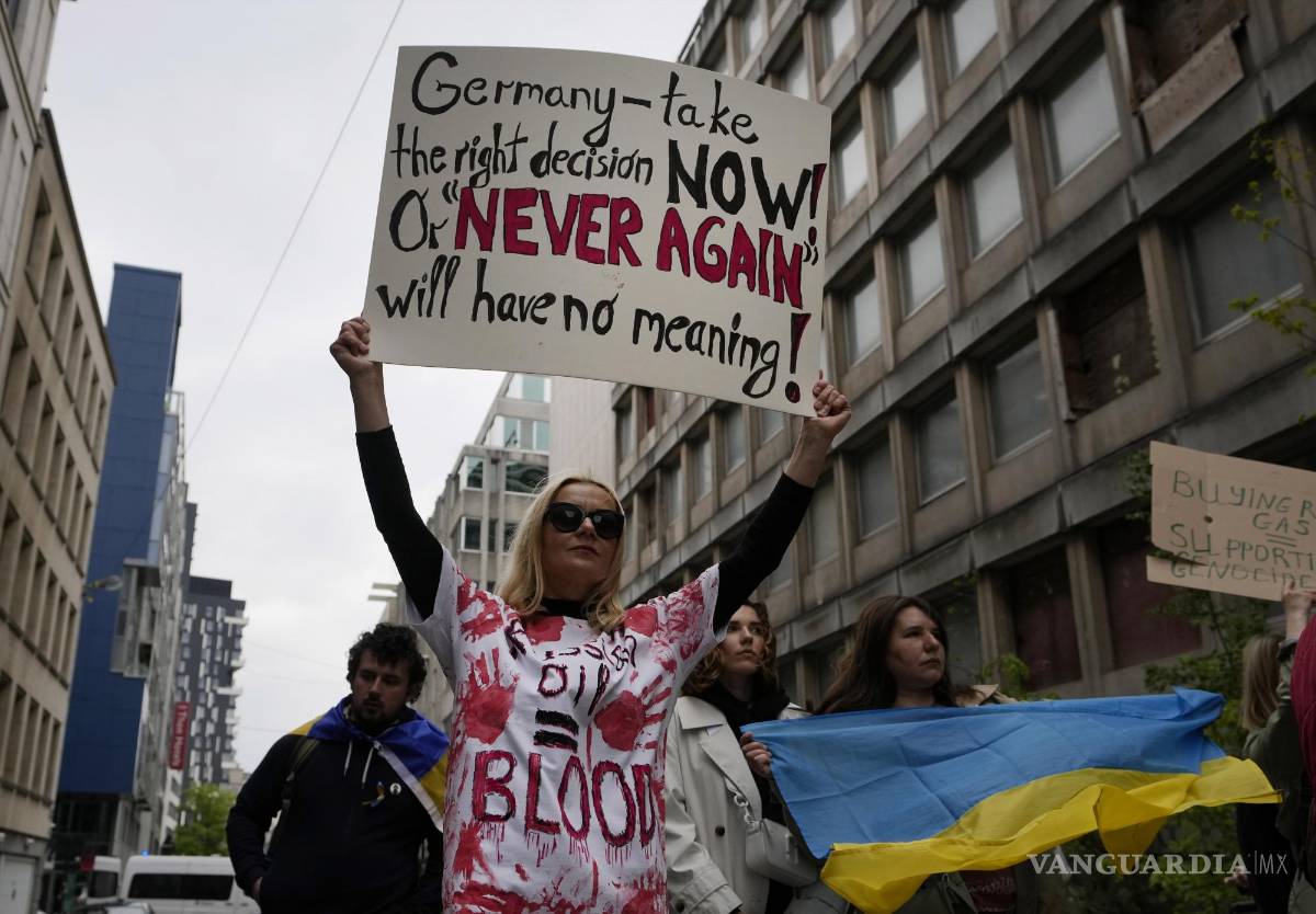 $!Una manifestante sostiene un cartel mientras protesta el Día de la Tierra frente a la embajada alemana en Bruselas.
