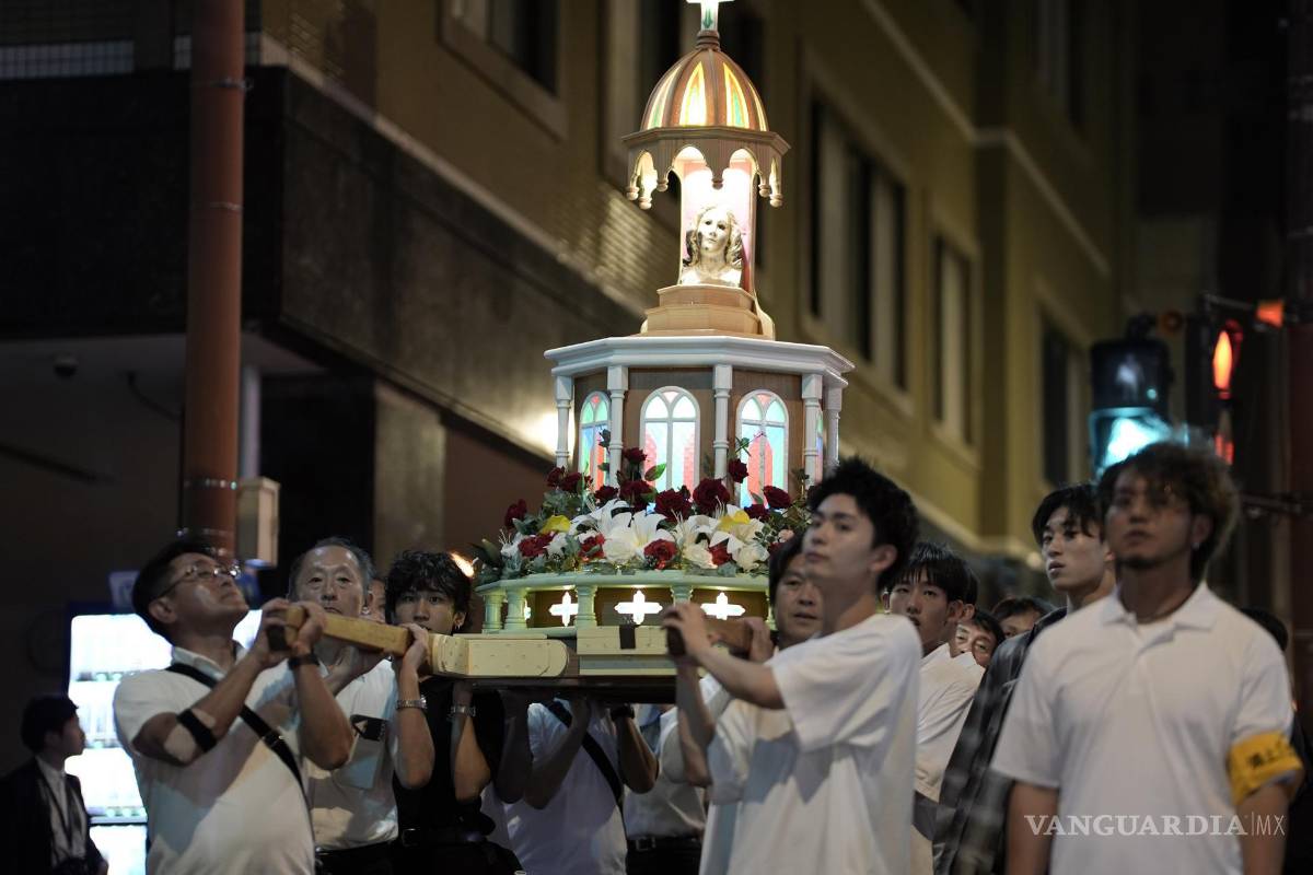 $!La gente lleva una plataforma con una estatua de la Virgen María que fue expuesta al bombardeo atómico, durante una procesión en Nagasaki.