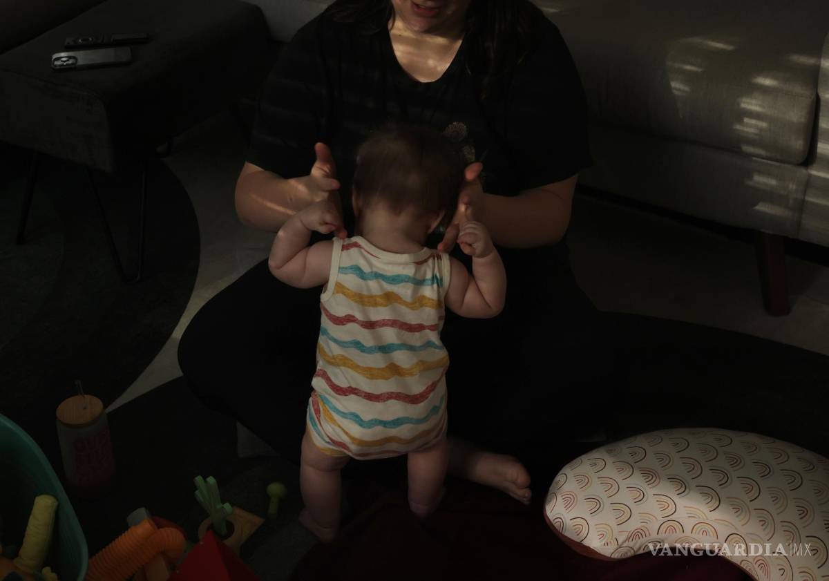 $!Una madre juega con su hijo de 9 meses en el piso de su sala el 1 de junio de 2023.