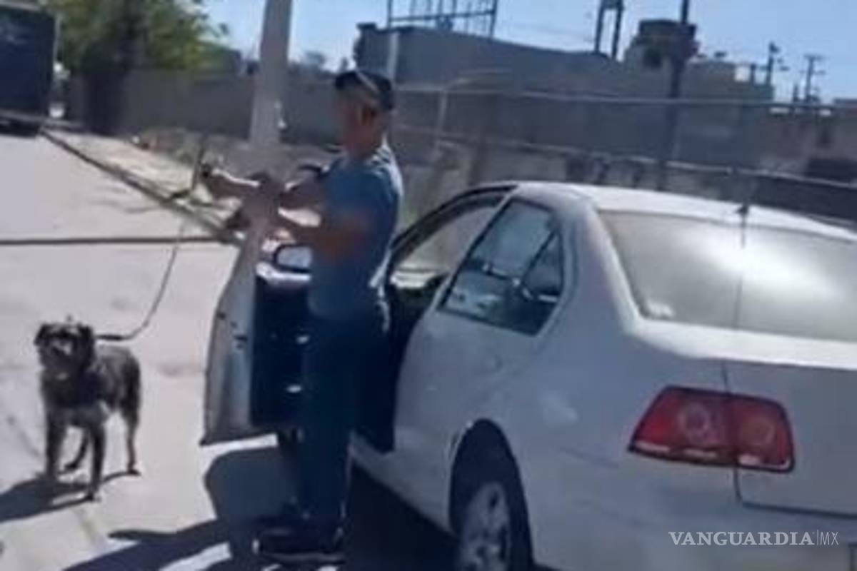 $!El conductor detiene su marcha y baja del auto, mientras sigue sosteniendo la correa de su perrito.