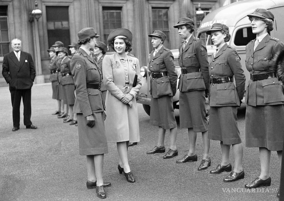 $!La princesa Isabel de Gran Bretñaa habla con una oficial de ambulancias en el Palacio de Buckingham en Londres el 24 de octubre de 1945.