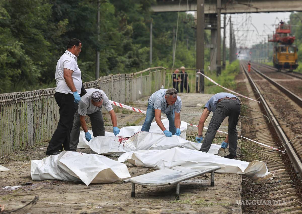 $!KYIV (Ukraine), 05/08/2026.- Special team members attend to the bodies of victims at the site of a Russian missile strike on a commuter train station near Kyiv, Ukraine, 05 August 2026, amid the Russian invasion. At least 17 people were killed, and more than 40 others were injured in a large-scale overnight Russian attack by ballistic missiles on Kyiv and its area, according to the Ukrainian State Emergency Service (SES). (Rusia, Ucrania, Kiev) EFE/EPA/SERHII DILIN