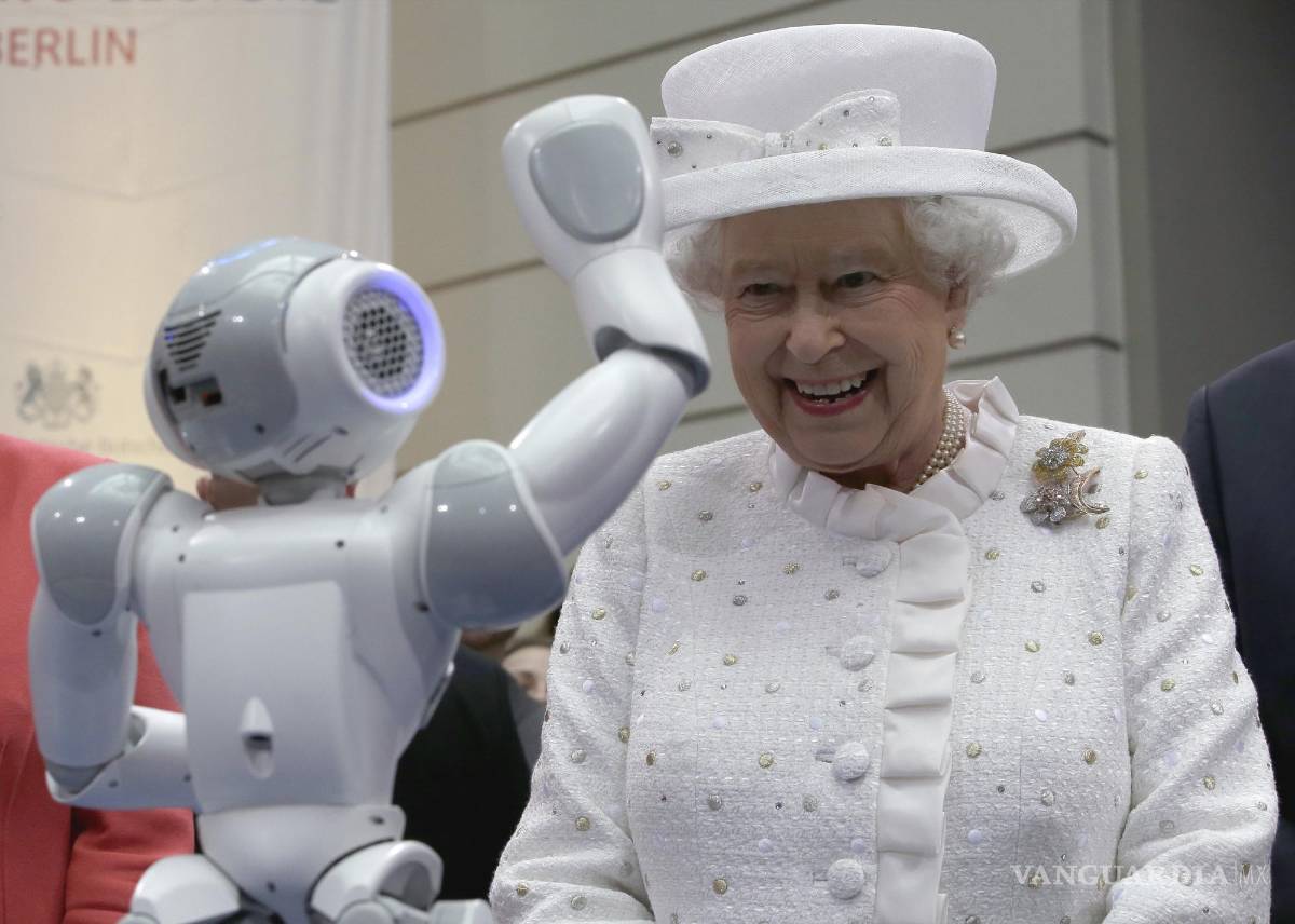 $!24 de junio de 2015, la reina Isabel II sonríe mientras un pequeño robot la saluda, en una recepción en la ‘Technische Universitaet’ en Berlín.