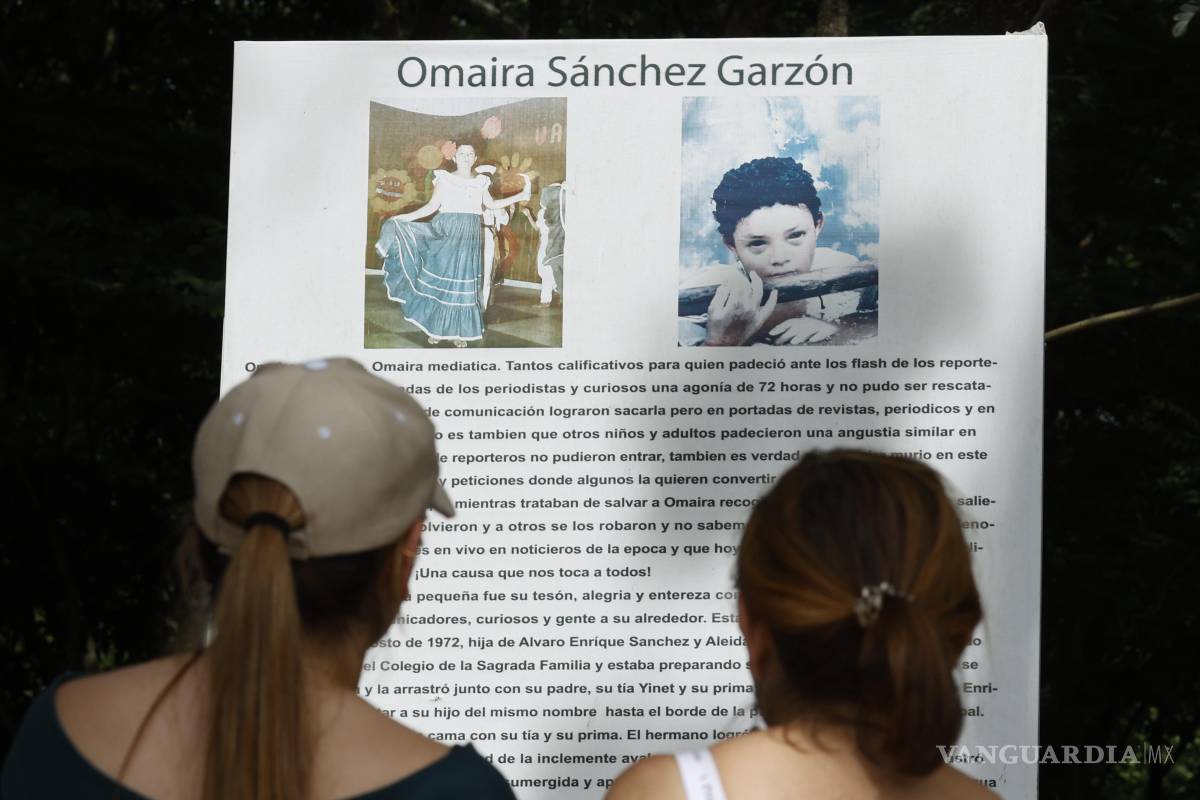 $!Fotografía del 5 de noviembre de 2025 que muestra a dos personas leyendo un cartel en un altar en honor a Omayra, en Armero, Colombia.