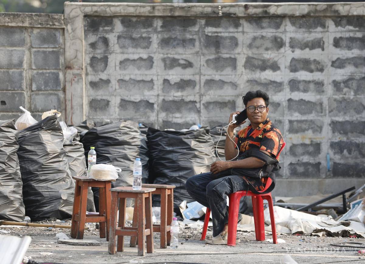 $!Un familiar espera a sus familiares desaparecidos durante una operación de búsqueda de sobrevivientes en el lugar de un edificio derrumbado en Bangkok.