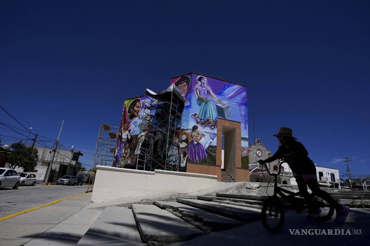 $!Una peatona monta su bicicleta frente a un mural pintado por el artista mexicano Jesús Rodríguez, en San Salvador, estado de Hidalgo (México)