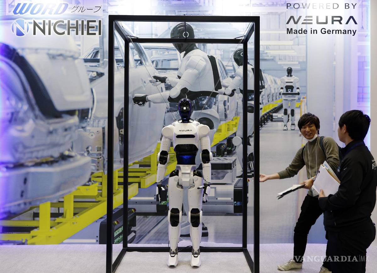 $!Los visitantes se encuentran junto a un robot humanoide exhibido en el stand de Neura durante la Exposición Internacional de Robots 2025 (iREX2025) en Tokio.