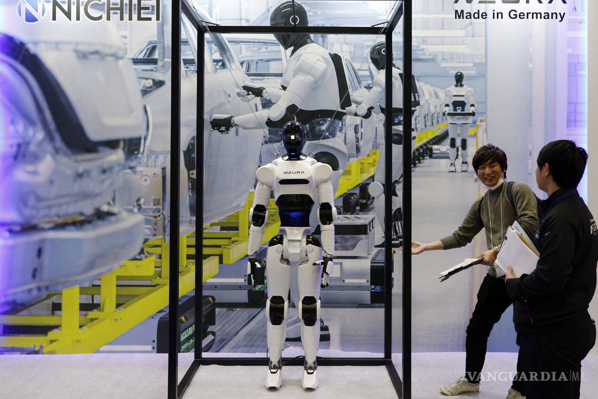 $!Los visitantes se encuentran junto a un robot humanoide exhibido en el stand de Neura durante la Exposición Internacional de Robots 2025 (iREX2025) en Tokio.