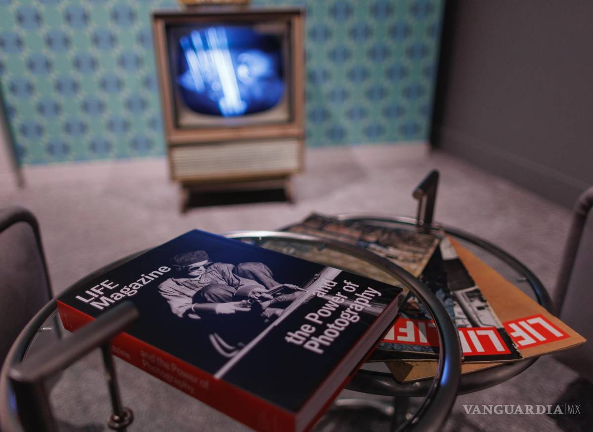 $!Copias de la revista Life y el catálogo de la exposición se exhiben en una mesa frente a un televisor que muestra el alunizaje de 1969.