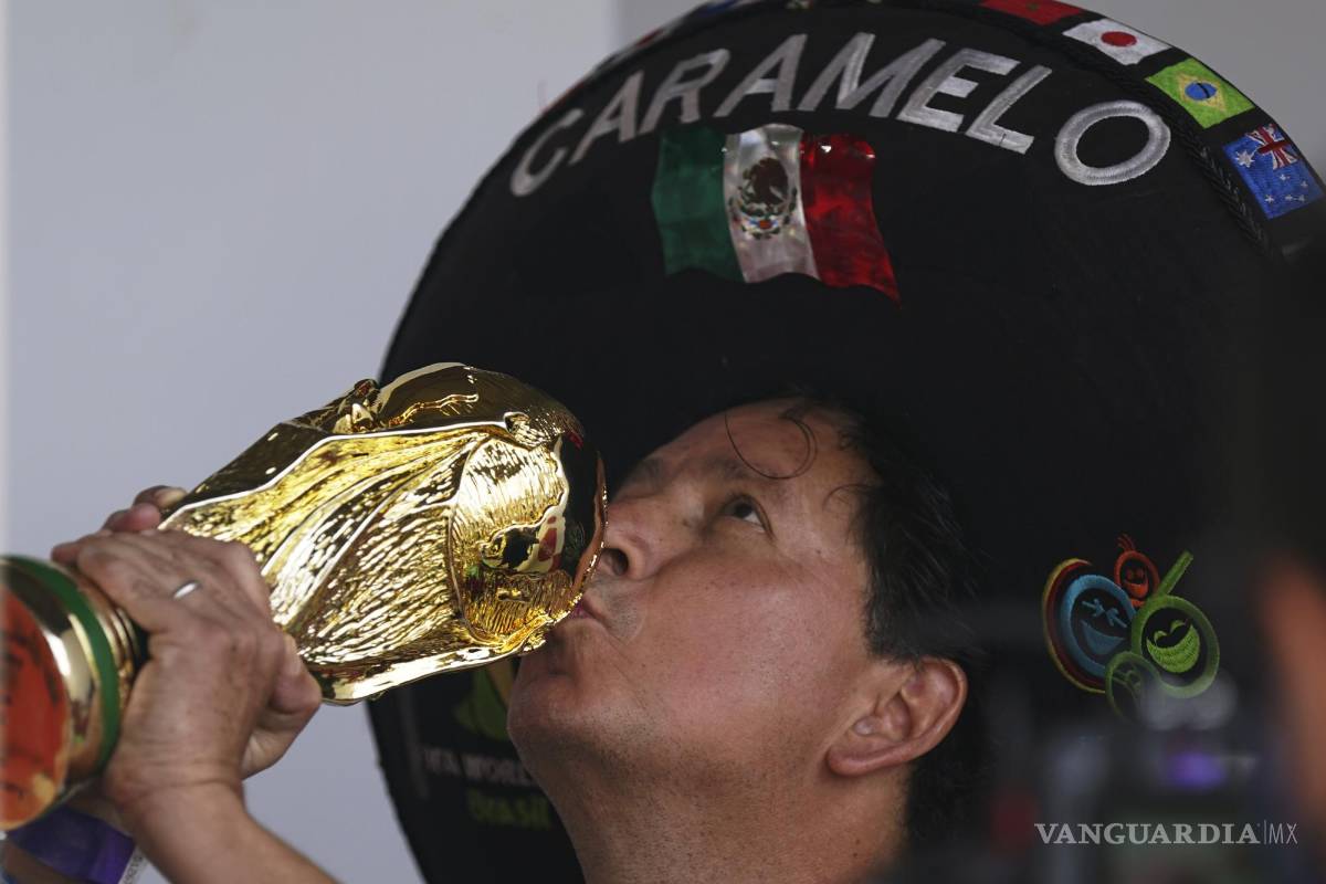 $!Héctor Chávez, hincha de la selección de México conocido como Caramelo besa una réplica de la Copa Mundial en Iztapalapa, Ciudad de México.