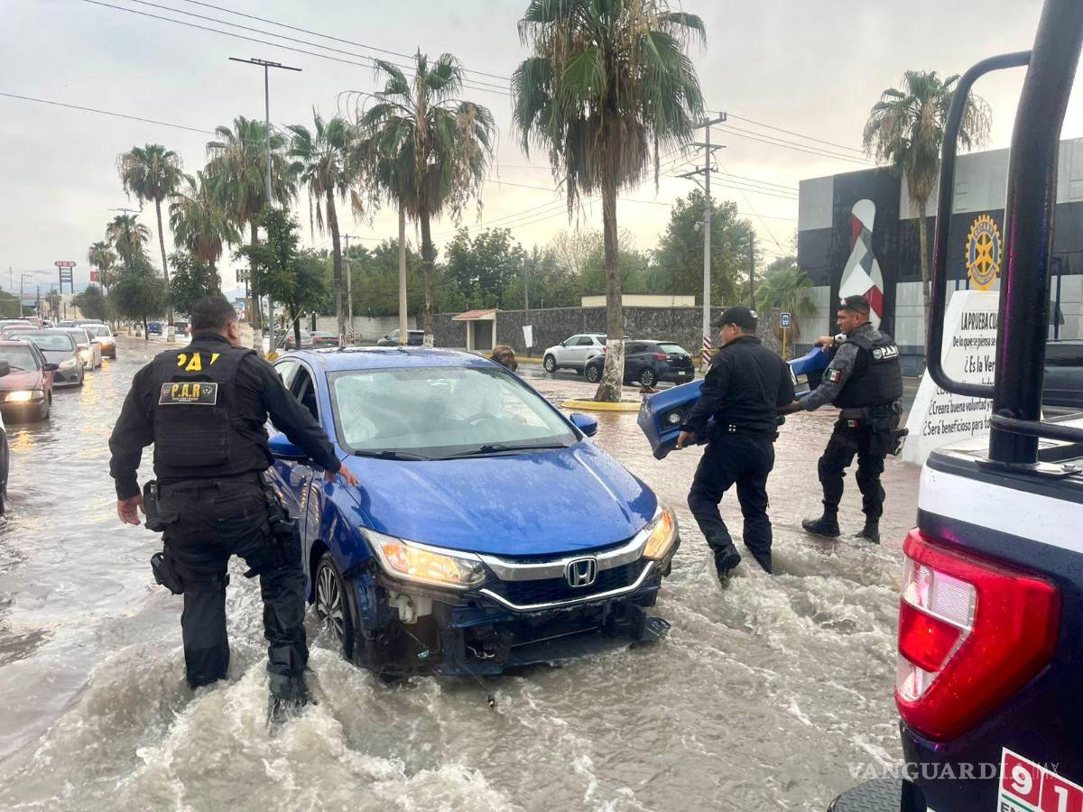 $!Elementos de seguridad auxiliaron a automovilistas que se quedaron varados enmedio del agua.