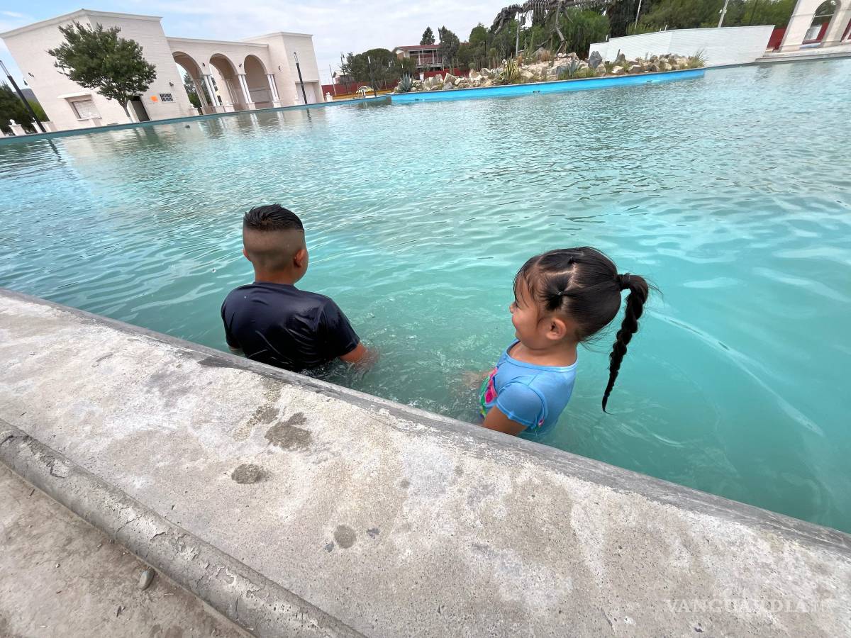 $!Algunas personas optaron por refrescarse en la fuente pública frente al parque.