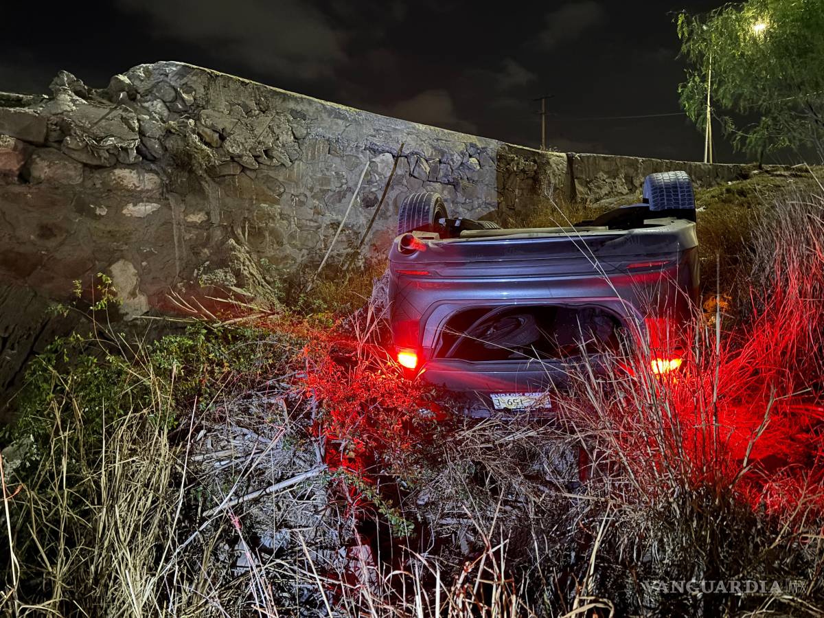$!La unidad quedó con las llantas hacia arriba luego de derribar un muro de concreto.
