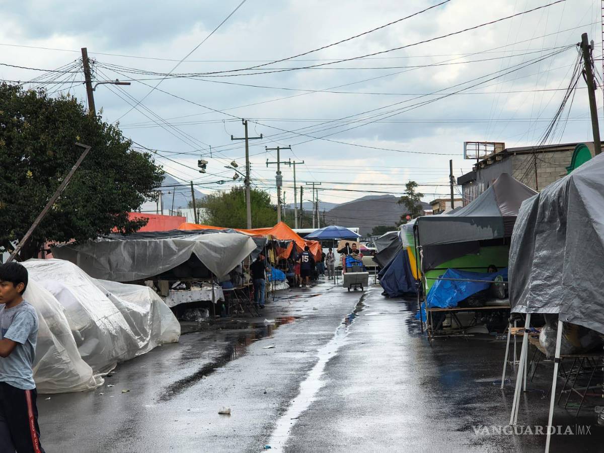 $!Debido a la sorpresiva lluvia, los puesteros del mercado de la Bellavista tuvieron que levantar su mercancía.
