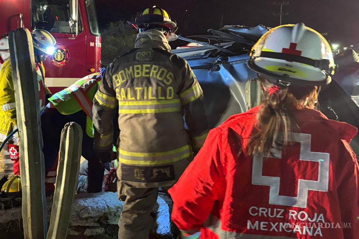 $!Bomberos y rescatistas de la Cruz Roja utilizan equipo hidráulico para retirar el techo del automóvil y liberar a los ocupantes atrapados tras la volcadura.