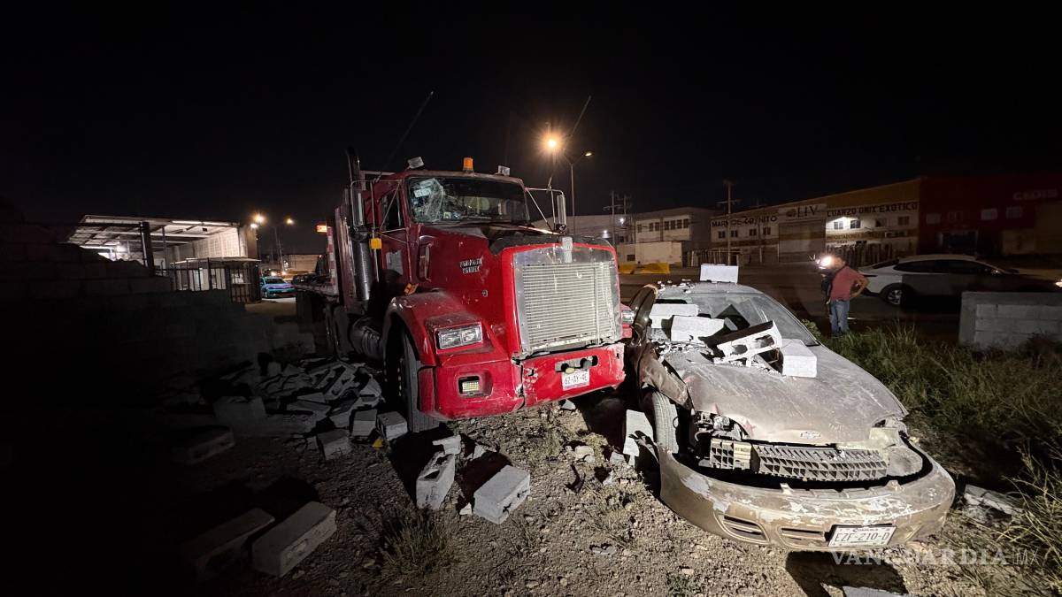 Tráiler sin conductor embiste un auto y tira una barda, en Saltillo