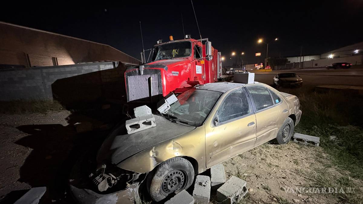 Tráiler sin conductor embiste un auto y tira una barda, en Saltillo