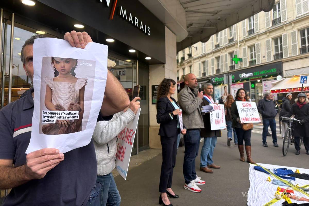 $!Un manifestante sostiene una fotografía de una muñeca sexual con apariencia infantil frente a los grandes almacenes BHV Marais en París.