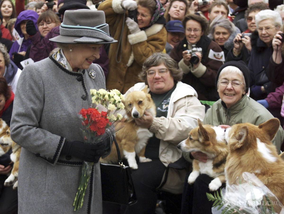 $!La reina Isabel II habla con miembros de la Asociación Manitoba Corgi, durante una visita a Winnipeg, el martes 8 de octubre de 2002.