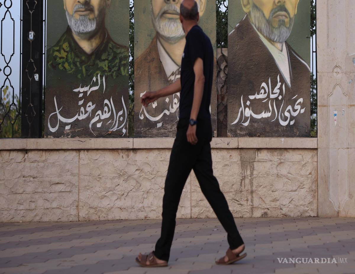 $!Un hombre pasa junto a pinturas que representan (de izquierda a derecha) al difunto comandante militar de Hezbolá, Ibrahim Aqil, y a los difuntos líderes de Hamás, Ismail Haniyeh y Yahya Sinwar, en Sana’a, Yemen.