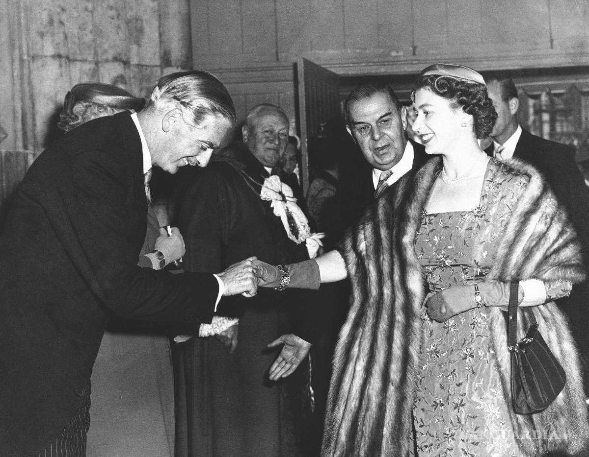 $!15 de mayo de 1956, el primer ministro británico Anthony Eden hace una reverencia a la reina Isabel II a su llegada al Guildhall de Londres.