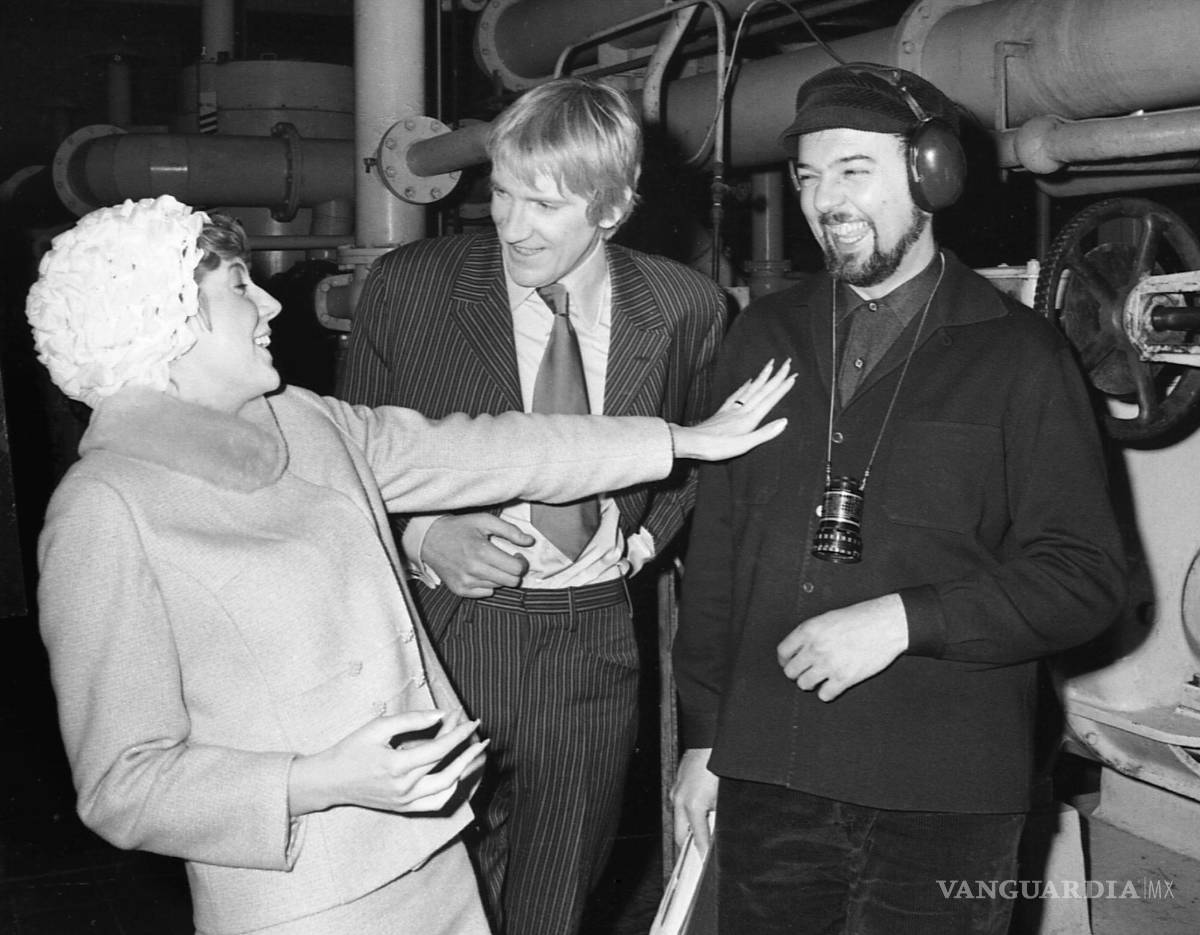 $!La cantante Cilla Black y David Warner (c) conversan con el director Peter Hall en un receso de la filmación de la comedia “Work... Is A Four Letter Word”.