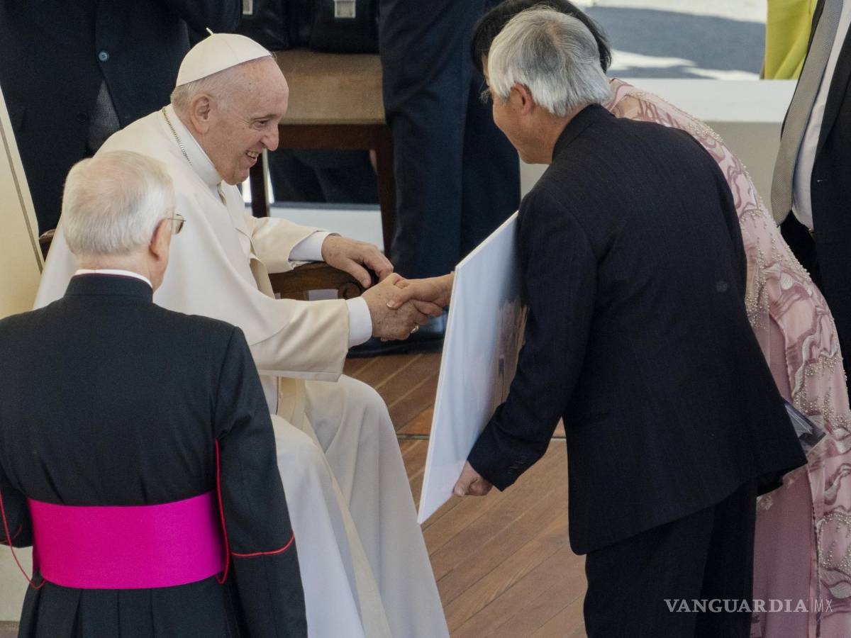 $!El fotógrafo ganador del premio Pulitzer, Nick Ut (c) y la embajador ade la UNESCO, Kim Phuc (d) le muestran al Papa Francisco la foto ganadora del Pulitzer de 1973.