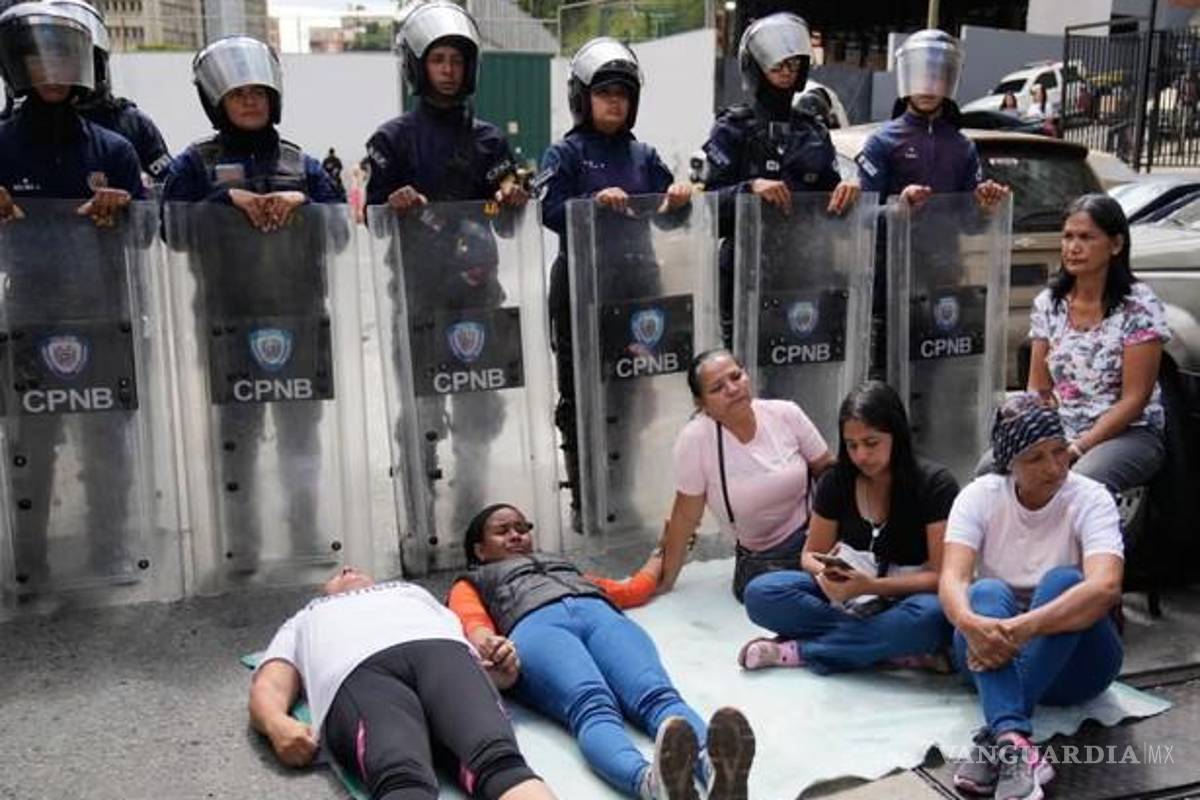 $!Familiares de presos políticos se tumban frente a la policía antidisturbios que custodia el centro de detención Zona 7 en Caracas.