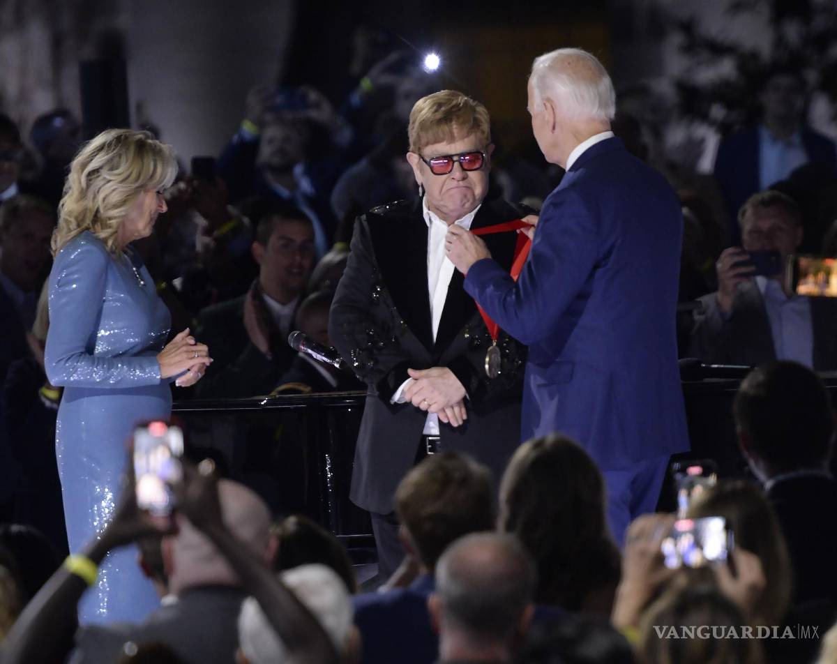 $!El presidente de los Estados Unidos, Joe Biden (derecha), entrega al cantante británico Elton John (centro) la Medalla Nacional de Humanidades.