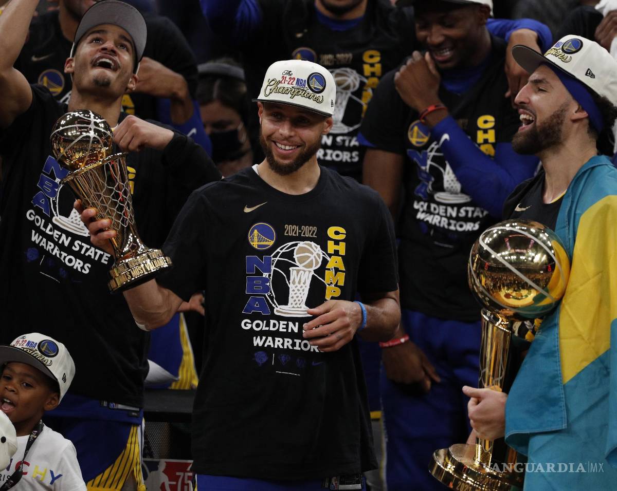 $!Stephen Curry, sostiene el Trofeo MVP de las Finales de la NBA (c) mientras el Jordan Poole (i), celebra con Klay Thompson (d).