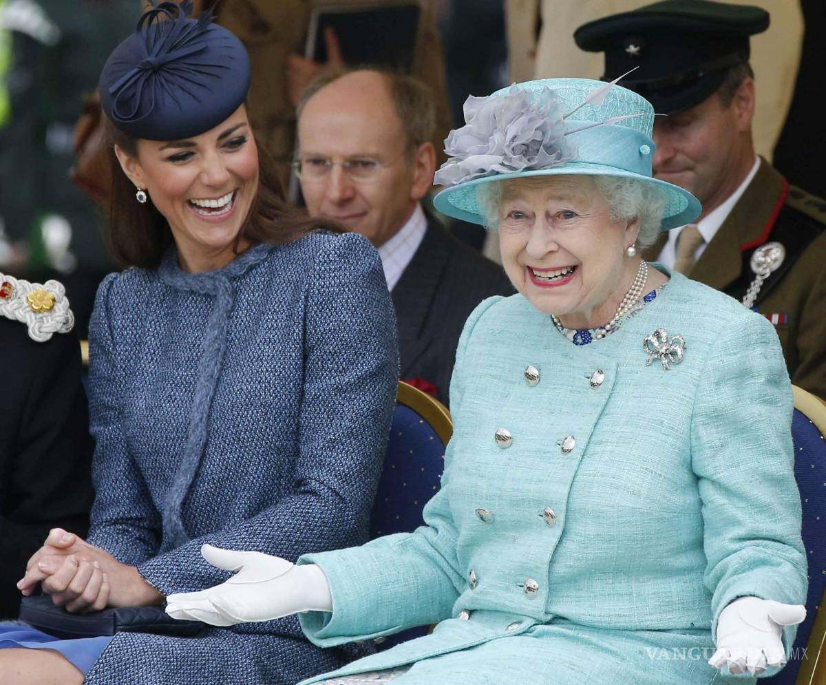 $!Catherine, duquesa de Cambridge (i) y la reina Isabel II ríen en un evento deportivo para niños en Vernon Park en Nottingham el 13 de junio de 2012.