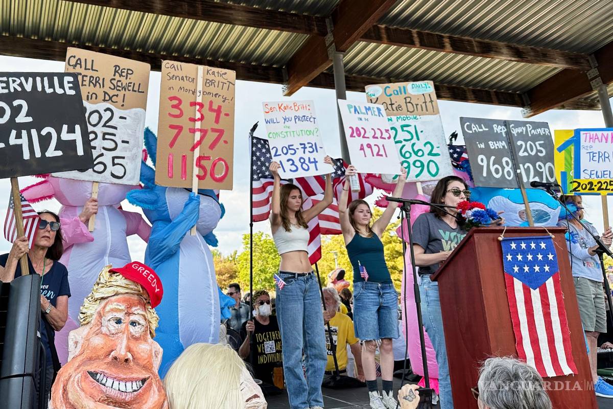 $!Becca Rothman y manifestantes con carteles con los números de teléfono de las oficinas de los representantes electos de Alabama durante la protesta “No Kings”.
